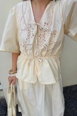 Blus i bomullspoplin med broderi och knytband