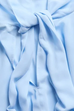 Chiffongblus med cape‑silhuett