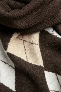 Stickad poncho med polokrage och rutmönster