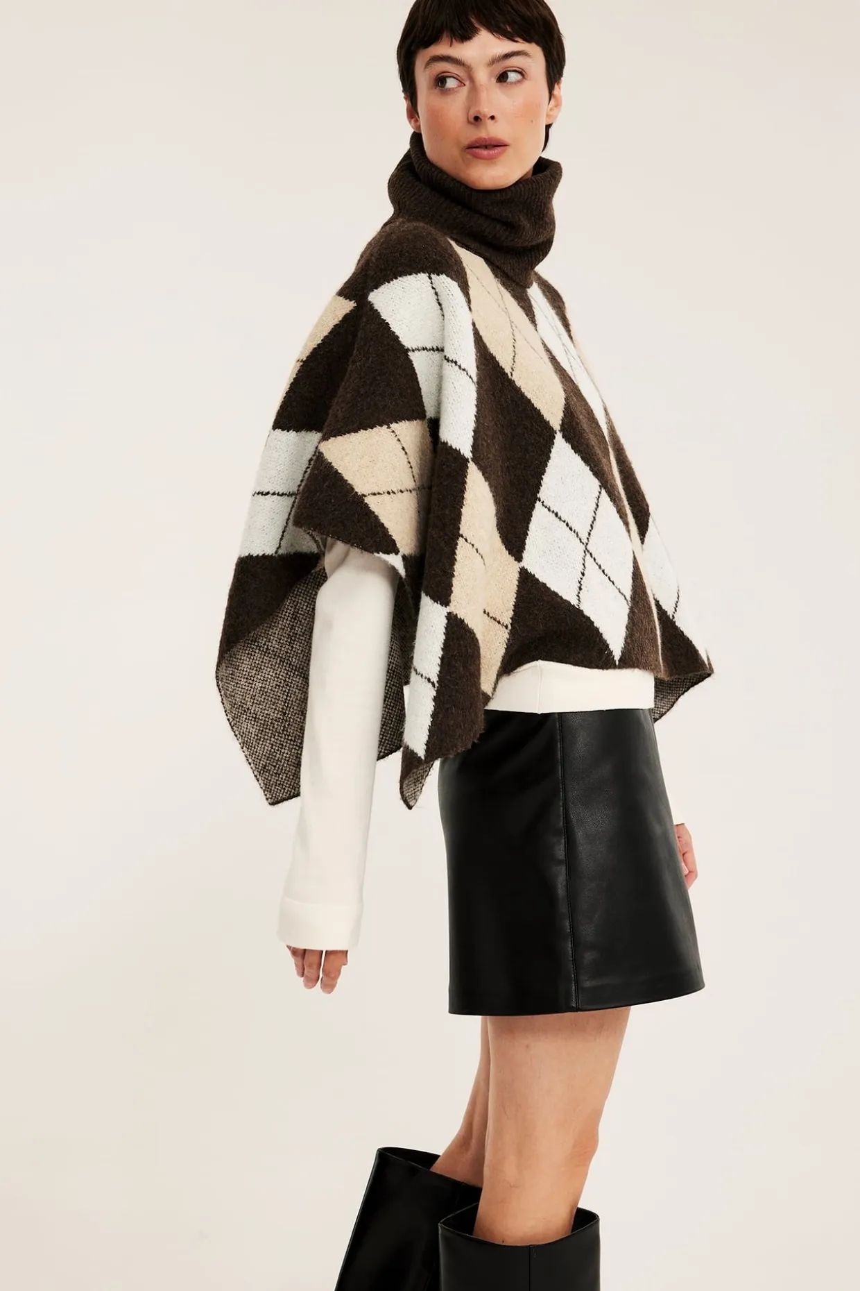 Stickad poncho med polokrage och rutmönster