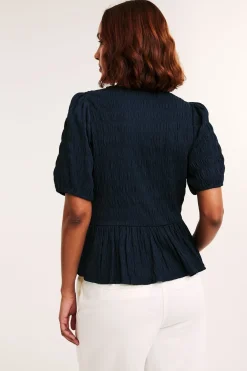 Strukturerad topp med peplum och kort ärm