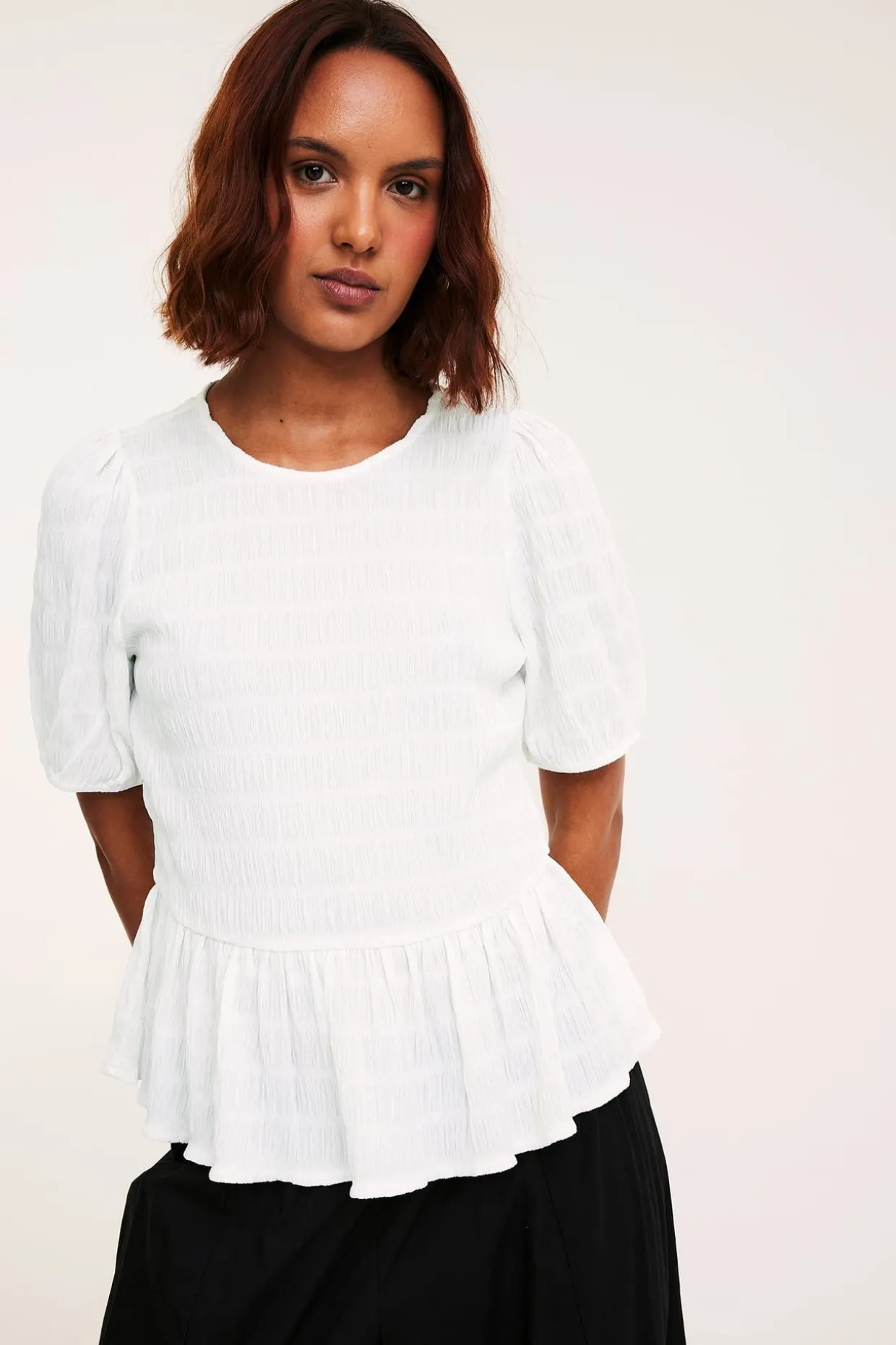 Strukturerad topp med peplum och kort ärm